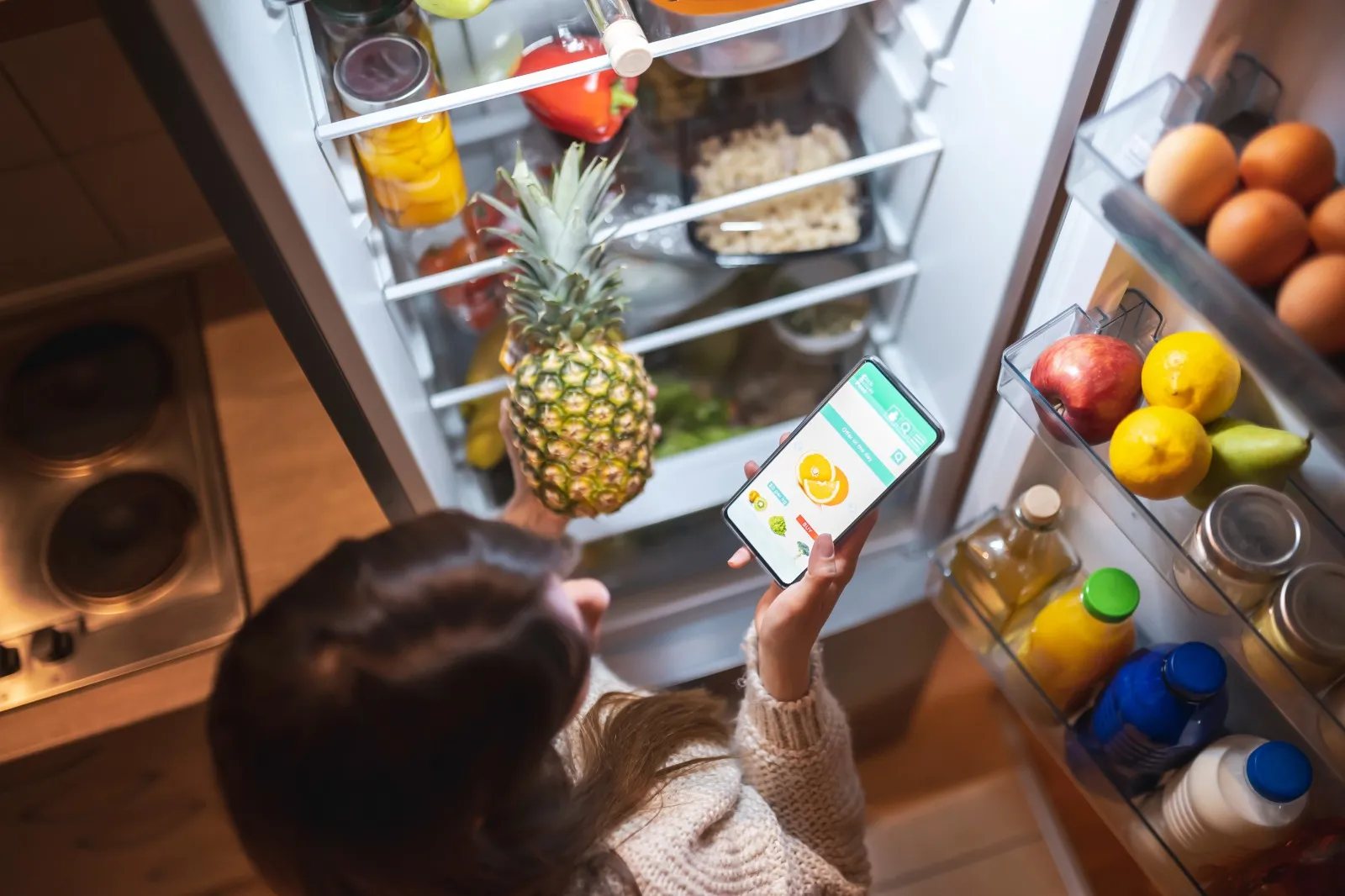 Technician repairing a refrigerator in a modern kitchen